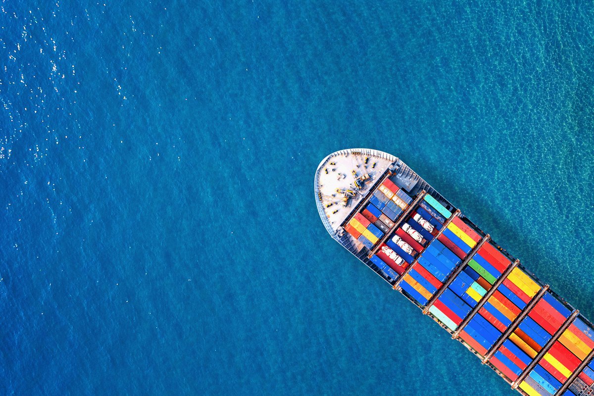 Container vessel viewed from above against blue ocean water.