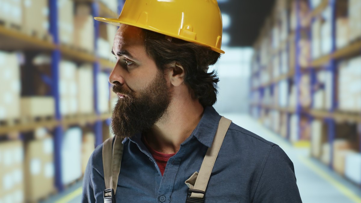Depot supervisor looking at pallet goods while checking cargo