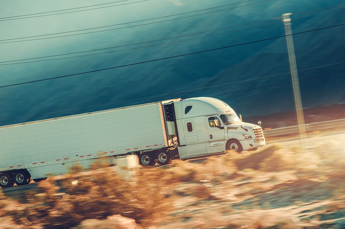 Speeding modern semi trailer truck on a desert highway