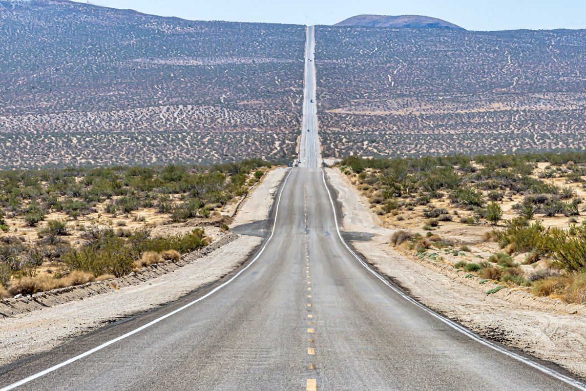 Straight highway crossing a U.S.-compatible desert landscape